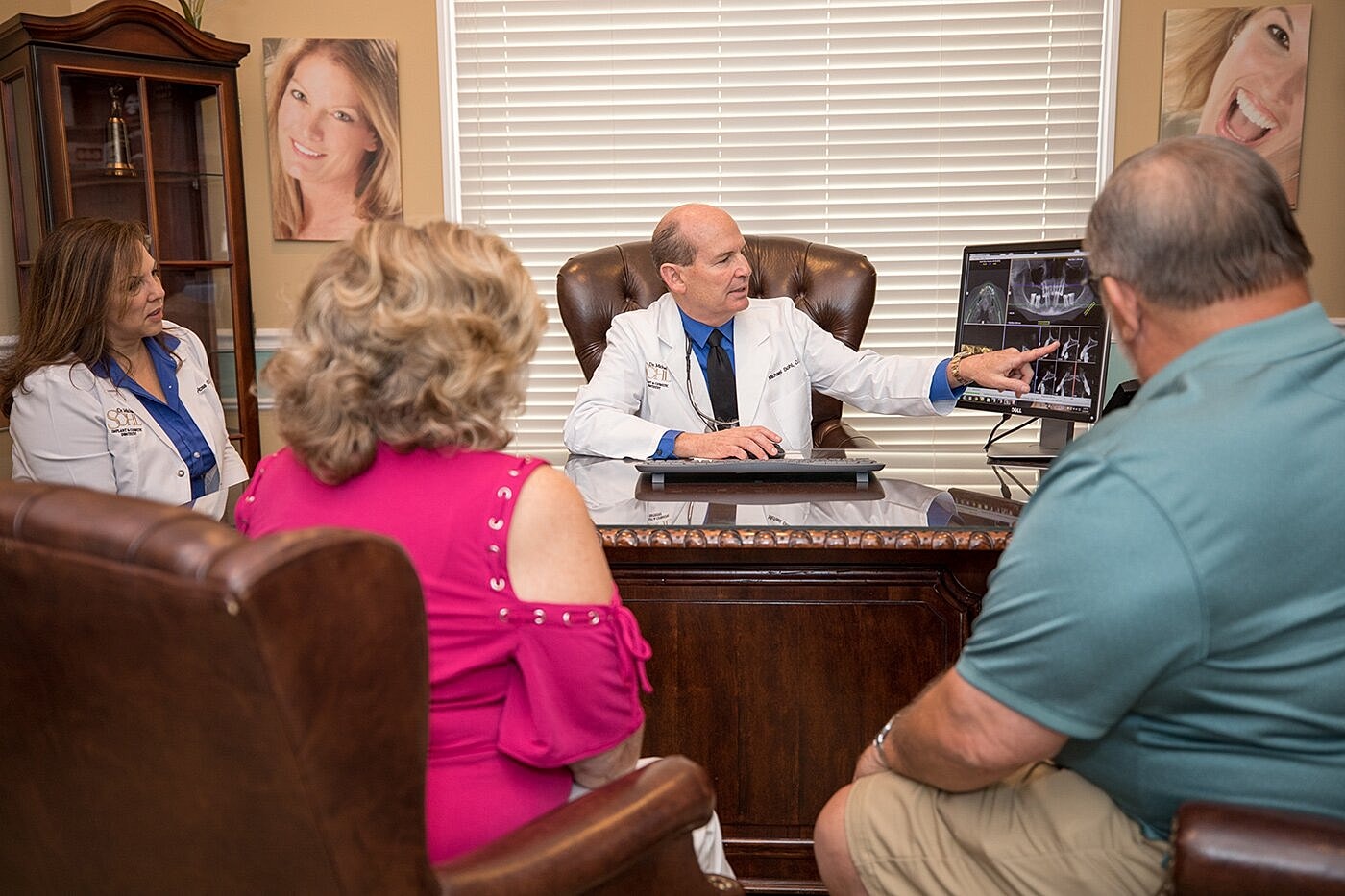 Doctor consulting with patients in office setting.