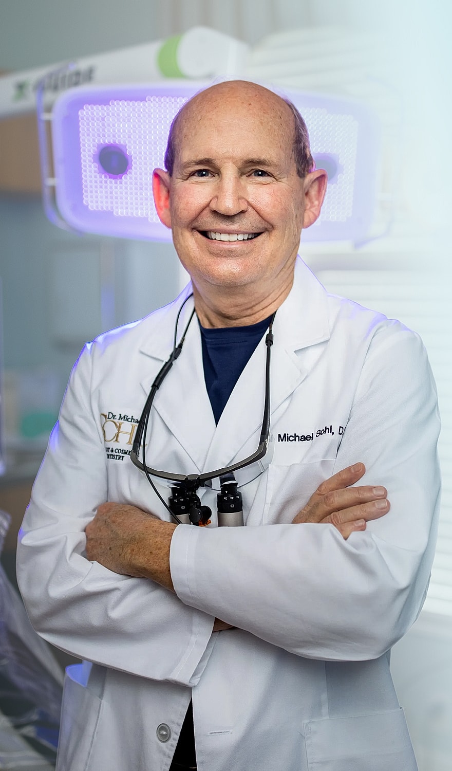 Smiling dentist in a clinical setting.