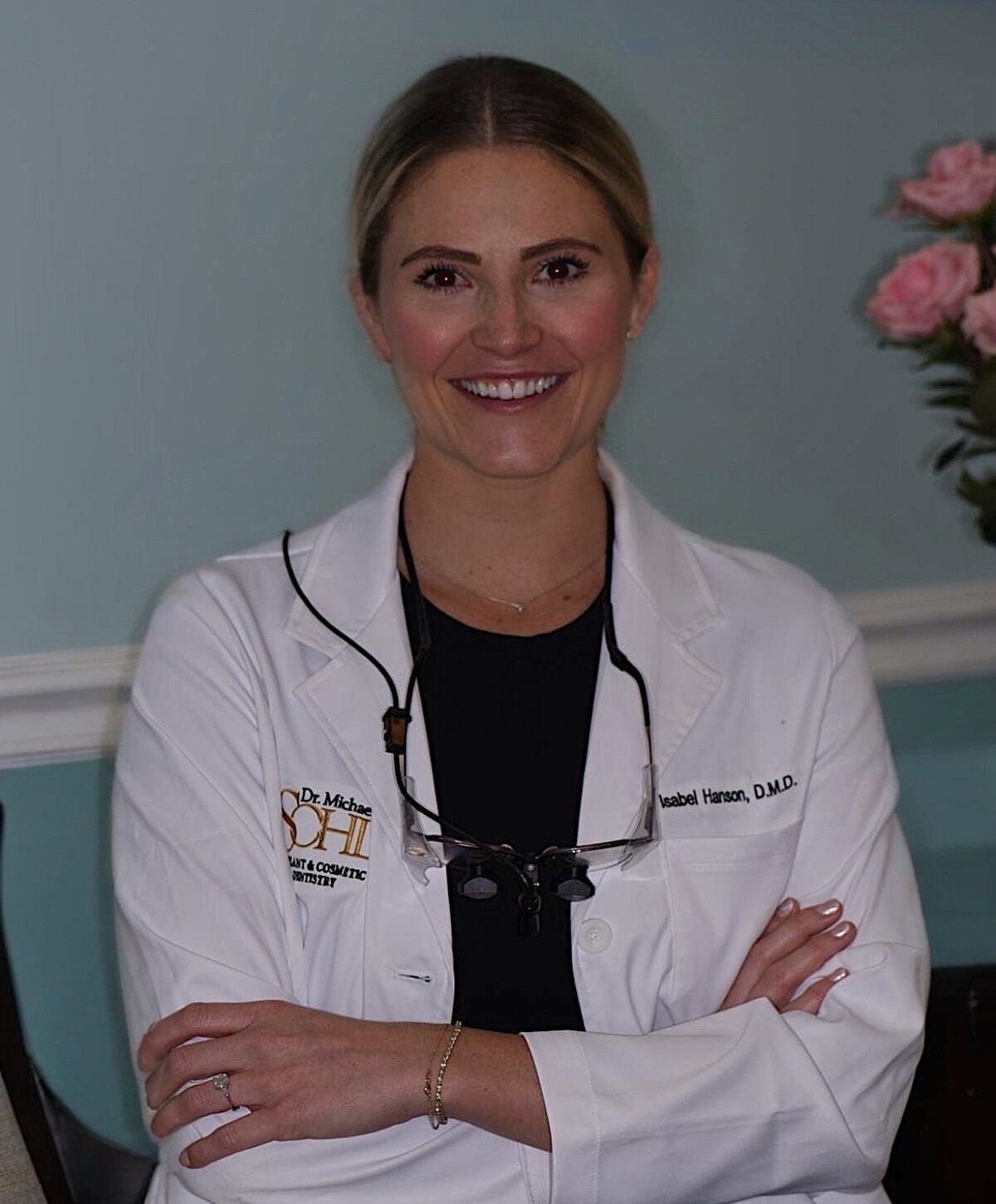 Female dentist smiling in professional attire.