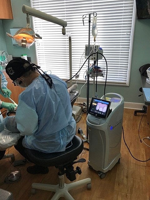 Dental procedure in a clinical examination room.