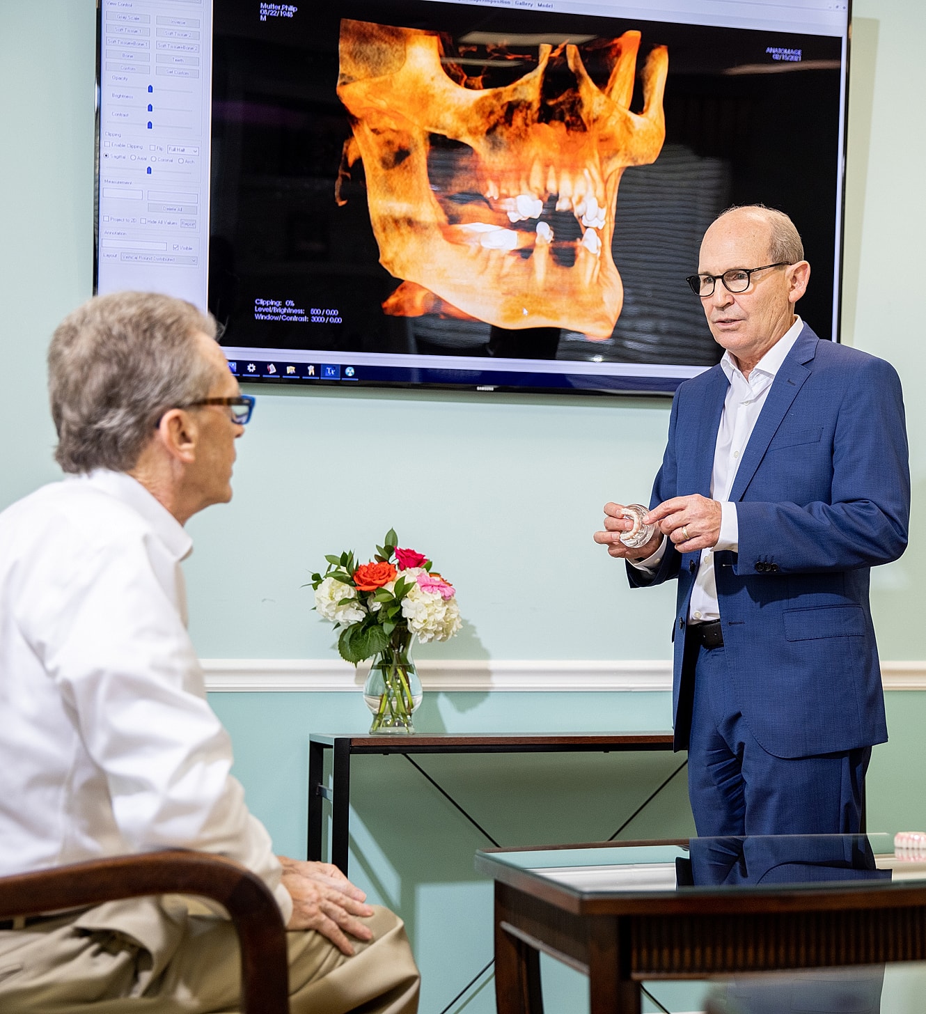 Dentist explaining treatment with digital imaging display.