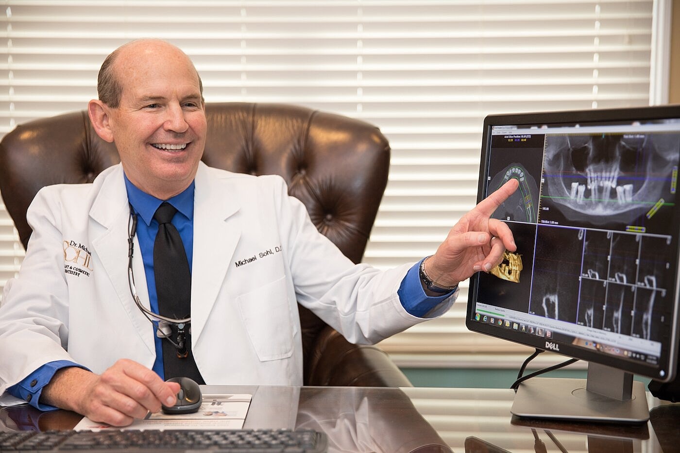 Doctor discussing dental images on computer screen.