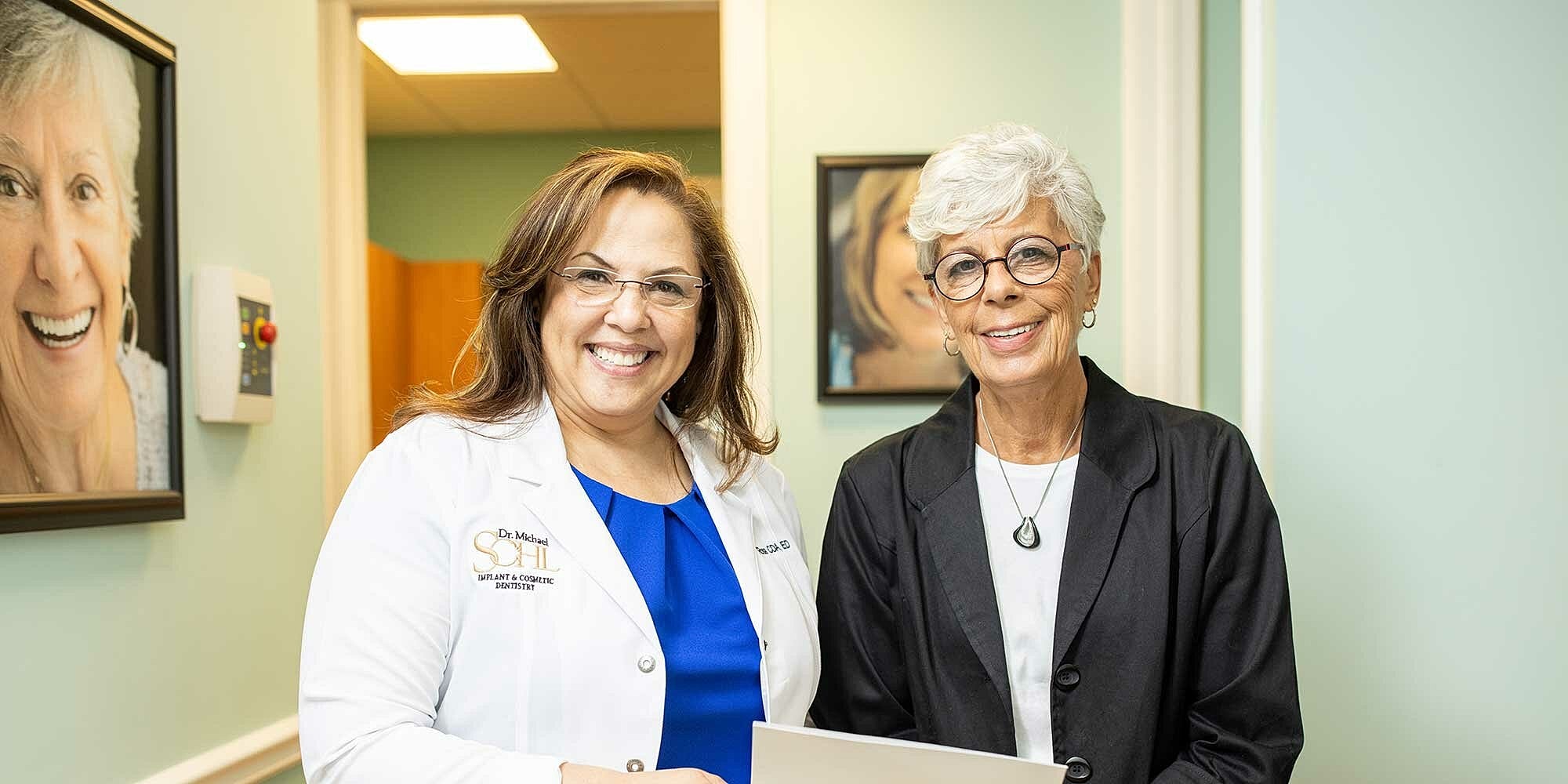 Two women smiling in a healthcare setting.