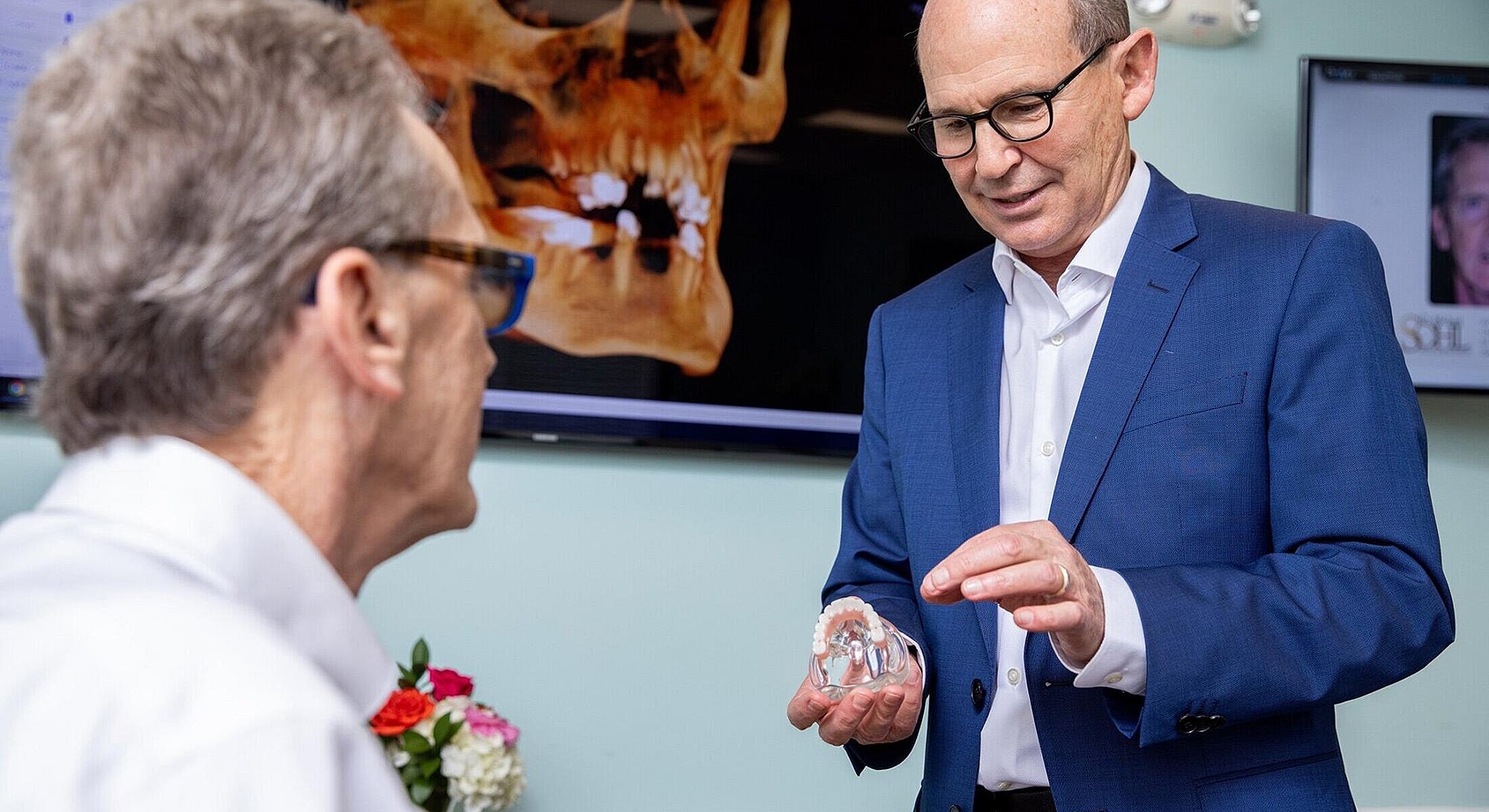 Doctor explaining treatment with dental model.