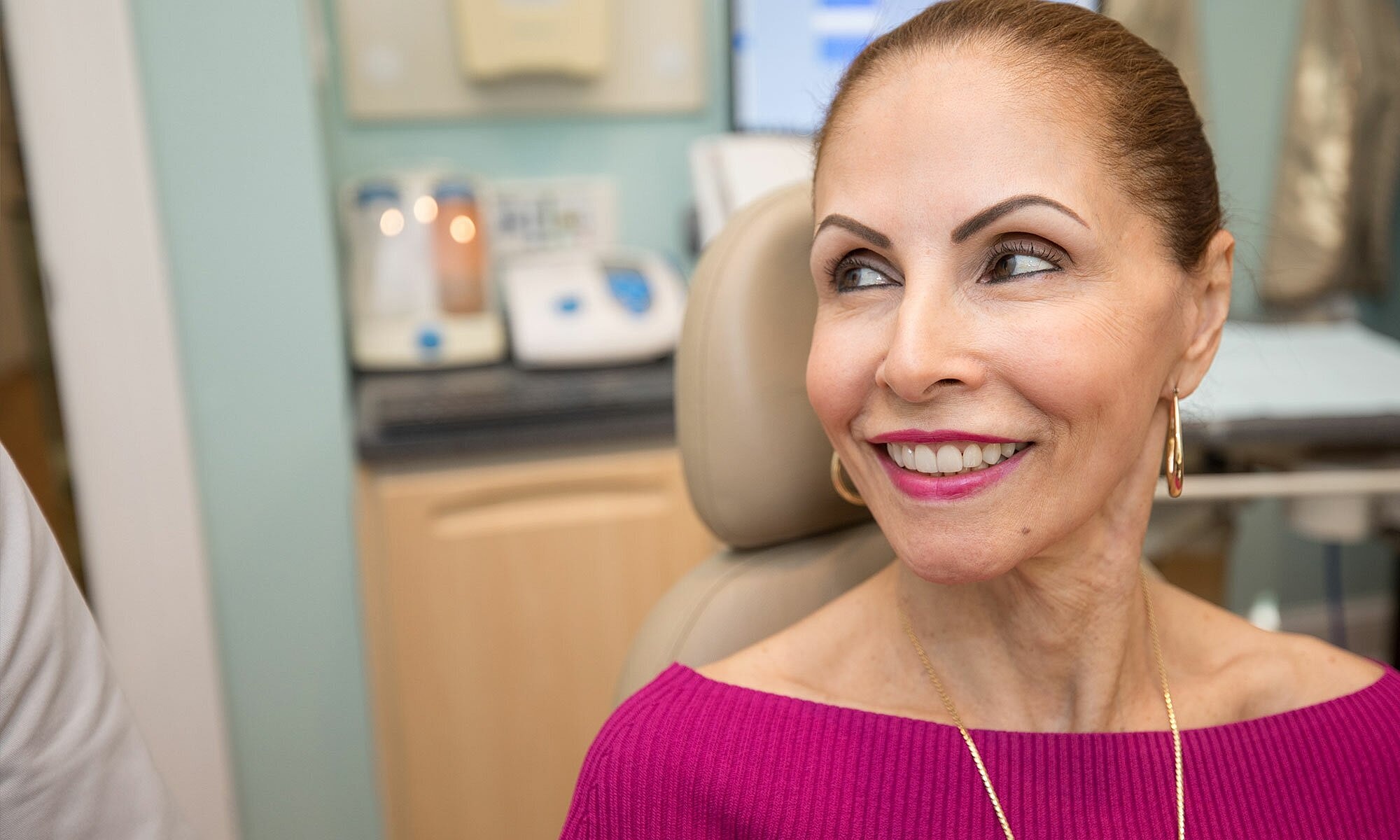 Patient smiling in dental office setting.
