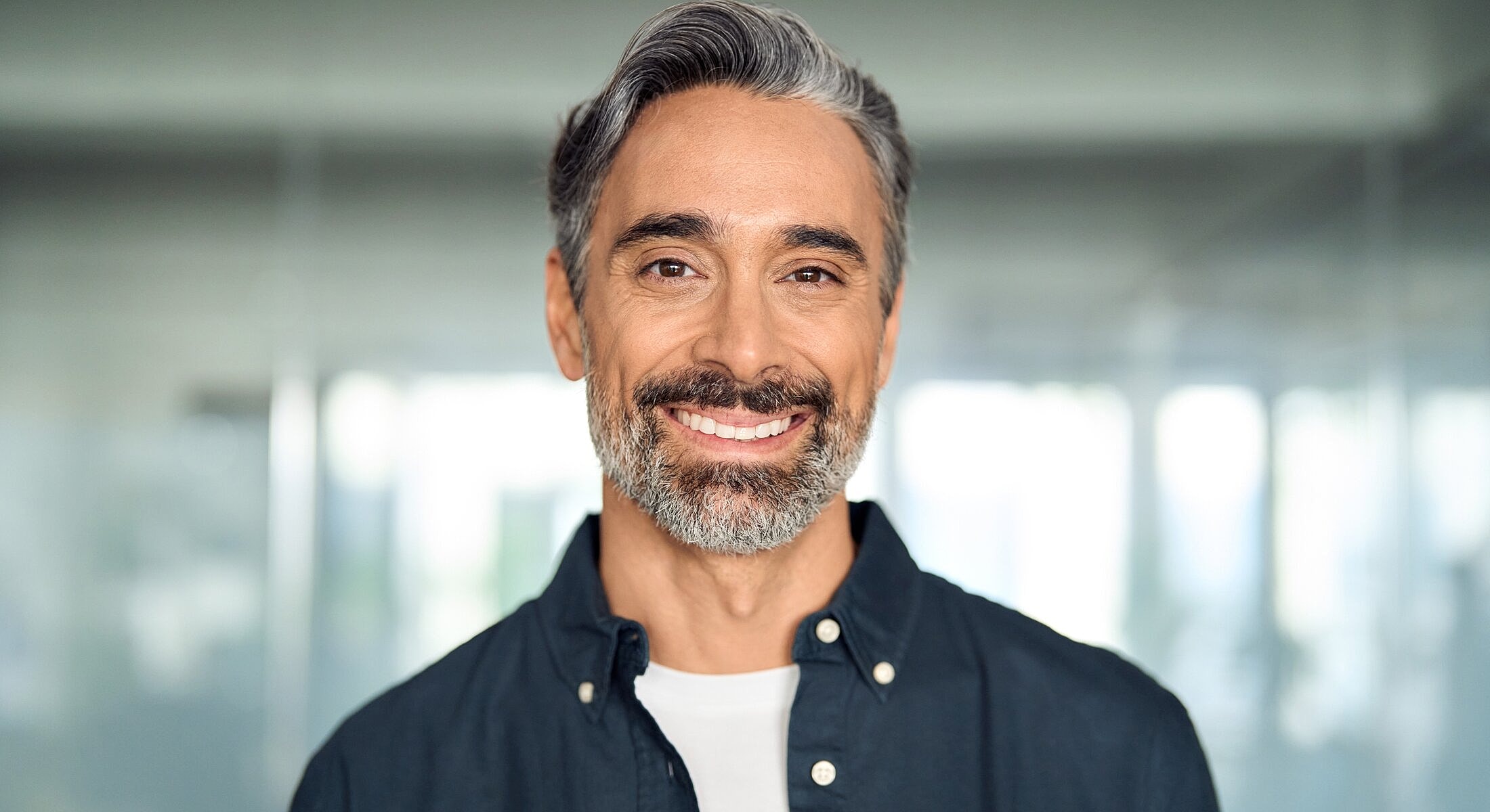 Smiling man with gray hair and beard.