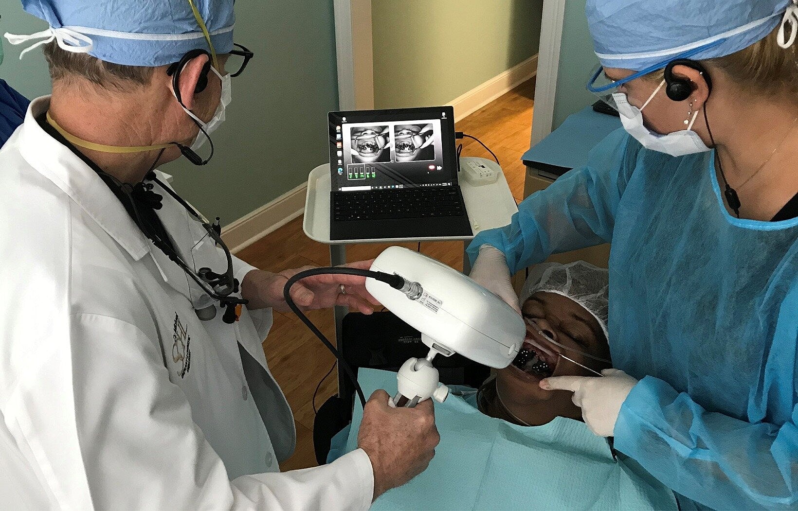 Dentists conducting a procedure on a patient.