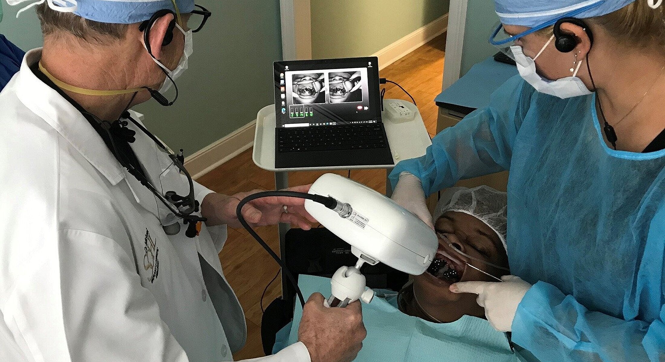 Dental procedure with patient and equipment involved.
