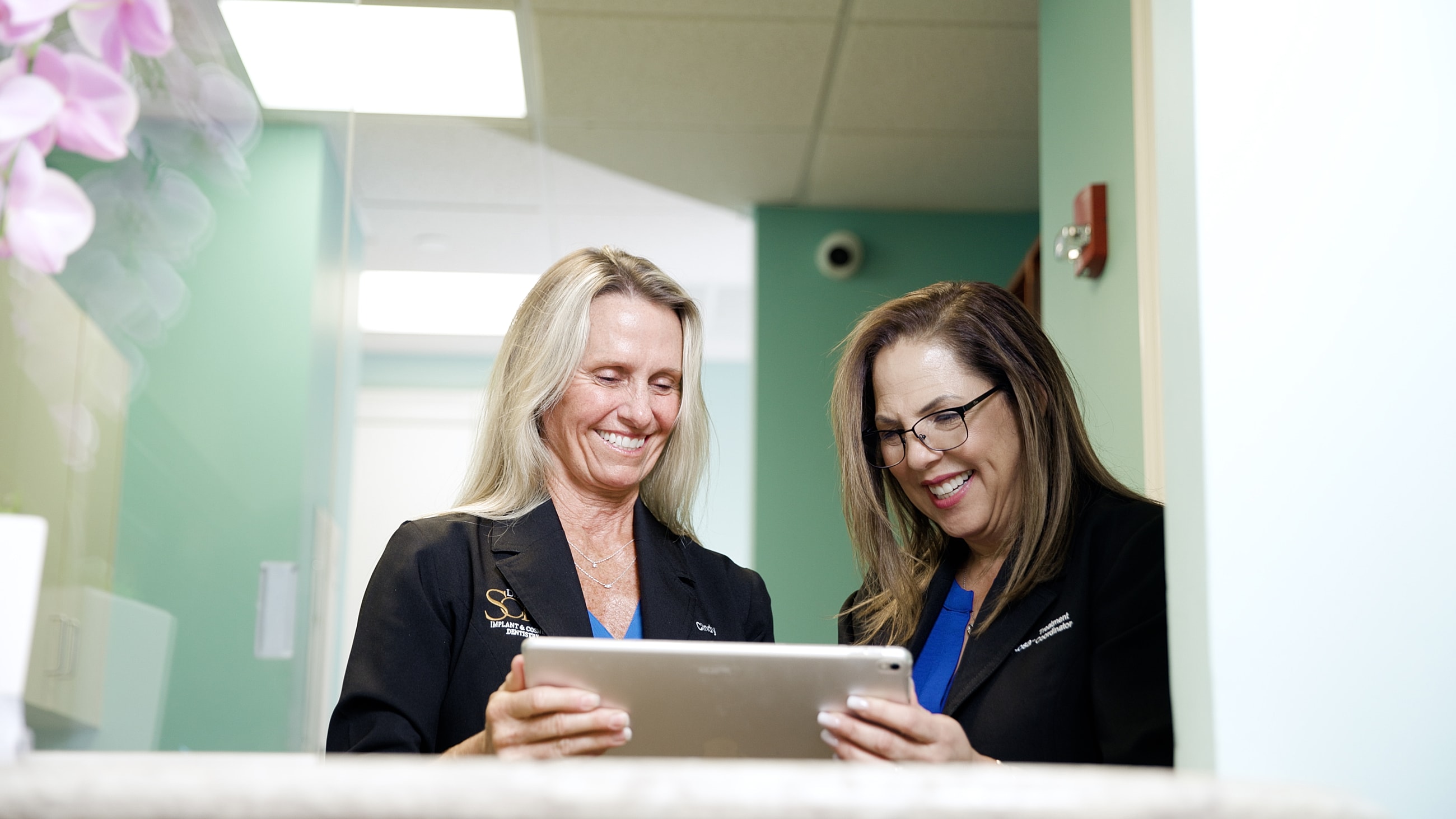 Two women discussing work on a tablet.